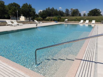 Scalini ingresso piscina circondata da terreno e alberi